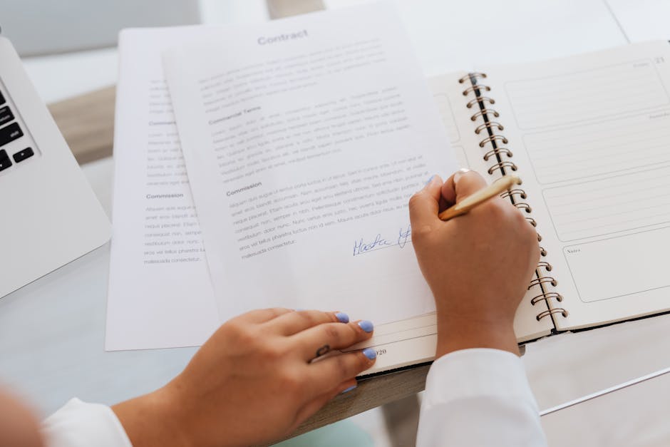 Personal injury attorney case file: a stack of legal documents and a yellow legal pad on a wooden desk with a pen, the kind of organized file a personal injury attorney builds during the first 60 days of intake, demand-letter preparation, and medical-record review on a typical U.S. injury claim
