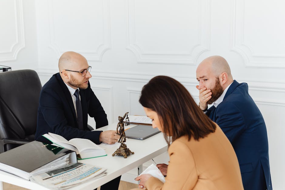 Estate planning attorney consultation context: a calm professional office with leather-bound legal books, a polished desk, and two people reviewing estate documents together, the kind of working session where an estate planning attorney walks a family through wills, trusts, powers of attorney, and beneficiary designations