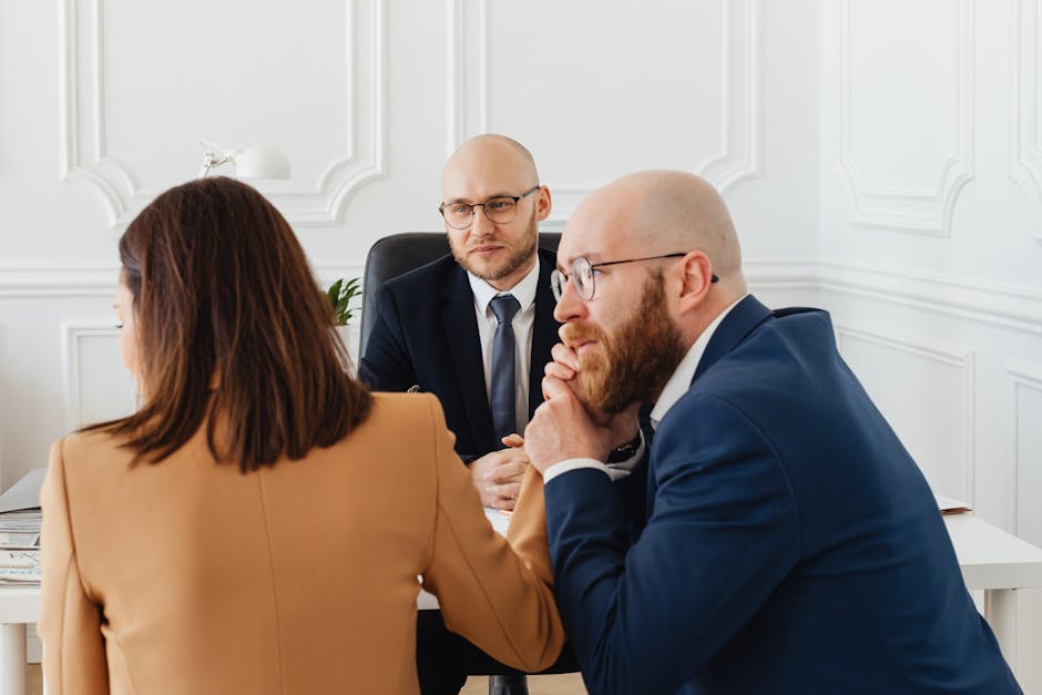 Bankruptcy attorney consultation context: a calm professional office with two people seated across a desk reviewing a household financial summary and a means-test worksheet, the kind of careful first meeting where a bankruptcy attorney walks a consumer through the realistic differences between Chapter 7 and Chapter 13 filings
